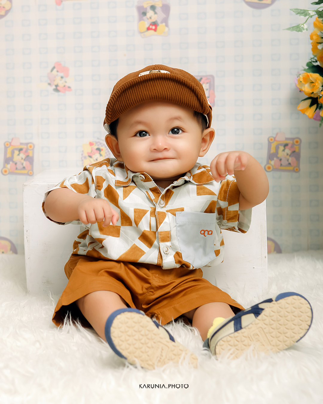 Toddler playing with bubbles in a sunlit meadow wearing a floral summer dress
